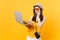 Sad upset tourist woman in summer casual clothes, hat holding laptop pc computer isolated on yellow orange background