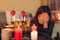 Sad woman crying at home by romantic table setting with wine glasses. Left alone and brokenhearted on Valentine's