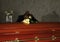 Sad woman mourning near casket with white roses in funeral