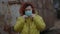 Sad woman puts on green protective face mask with hands in plastic gloves during coronavirus epidemic. Slow motion shot