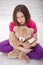 Sad young girl sitting with teddy bear