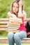 Sad young student girl sitting on bench with books