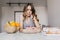 Sad young woman with curly hairstyle looking at cake. Indoor photo of pensive girl expressing negat