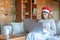 Sad young woman with Santa hat watching a movie in front of the laptop