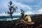 Sad young woman sitting on burned hill