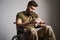 Saddened military man sitting in a wheelchair and holding a bottle of pills