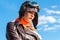 Sadness woman in aviator helmet on the sky background