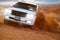 Safari on the car SUV through orange dunes in the desert