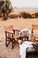 Safari luxury outdoor picnic with African style wooden director chair with wine bucket on table