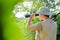 Safari tour: picture of male tourist or exploring scientist in pith helmet having fun observing looking in magnification scope