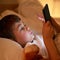 Safe in bed and thanks to parental control, safe online. a young boy using a digital tablet while lying in bed.