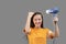 Safe drying. Young caucasian woman dries hair with a hairdryer on gray background, having fun