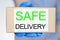 Safe home delivery concept. A courier in a protective glove holds a parcel.