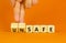 Safe or unsafe symbol. Concept word Safe Unsafe on wooden cubes. Businessman hand. Beautiful orange table orange background.