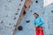 Safety climbing. Young man professional rock climber checking sports equipment before climbing at training center in