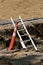 Safety cone recognizes danger where a ladder reaches out of a trench