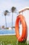 Safety equipment, Red lifebuoy pool ring float, ring floating in refreshing blue swimming pool. Red float floating on the pool bea