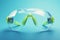 Safety eyewear focus Technological green glasses isolated on blue background