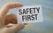 Safety first in unsafe workplace concept photo. Hand of staff is holding the text sign with blurred background