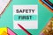 SAFETY FIRST written on a turquoise background near bright stickers, notepads and markers