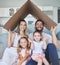 Safety, happy and portrait of family with a roof or covering gesture with cardboard in the living room. Happiness, smile