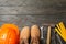 Safety helmet, boots and construction tools on background, space for text