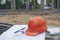 Safety helmet hard hat, blueprint, glasses, and drawings paper for engineer, safety officer or architect, place on wooden floor