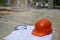 Safety helmet hard hat, blueprint, glasses, and drawings paper for engineer, safety officer or architect, place on wooden floor