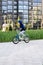 Safety in a modern European city. A little happy boy rides a bicycle through a closed courtyard in a multi-storey urban