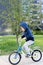 Safety in a modern European city. A little happy boy rides a bicycle through a closed courtyard in a multi-storey urban