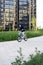 Safety in a modern European city. A little happy boy rides a bicycle through a closed courtyard in a multi-storey urban