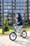 Safety in a modern European city. A little happy boy rides a bicycle through a closed courtyard in a multi-storey urban