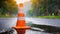 Safety orange cone on wet asphalt after rain. Plastic traffic cone. Road maintenance work