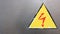 Safety sign yellow and red on a silver metal background. High voltage lightning in a triangle caution caution danger electricity