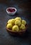 Saffron flavoured desiccated coconut ladoo in a wooden bowl