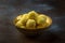 Saffron flavoured desiccated coconut ladoo in a wooden bowl