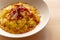 Saffron risotto close up, classic yellow colorful italian food staple dish on white plate on wooden table with speck, a gourmet