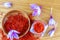 Saffron stigmas scattered on a wooden surface from a glass bottle. Saffron crocus flowers