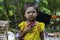 Sagaing/Myanmar-October 3rd 2019: A Burmese girl wears flashy colors and fingers in balloons of various colors