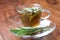 Sage tea with fresh sage inside teacup on wooden flooring