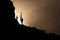 Saguaro cactus and a silhouetted mountain at sunset.