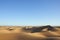 Sahara desert sand dunes with clear blue sky.