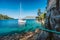 Sail boat on rope in emerald hidden lagoon among picturesque mediterranean nature Ionian Islands, Greece