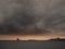 Sail boat silhouette going into the port, Dramatic stormy sky, Galway bay and city, Ireland. Atlantic ocean