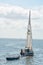 A Sail boat towing a dingy with a man and his labrador on the boat in calm waters. On Tampa bay Florida. No Model/Property Release