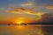 Sail boats reflecting in the calm ocean during a sunset