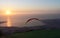 Sail of a paraglider in front of sunset landscape