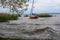 A sailboat alone waiting for a coming storm to pass