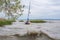 A sailboat alone waiting for a coming storm to pass