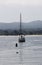 Sailboat Anchored In Bay With Hills In Background